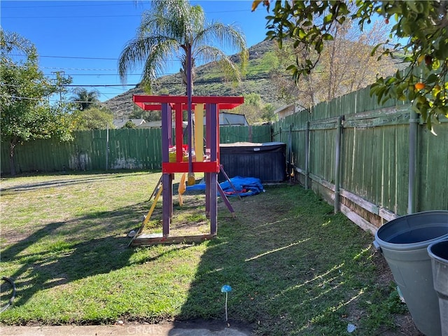 view of yard with a playground and a fenced backyard