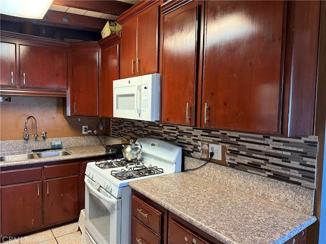 kitchen with light countertops, white appliances, a sink, and tasteful backsplash