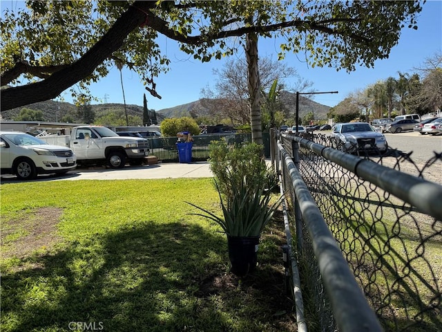 view of yard featuring fence and a mountain view