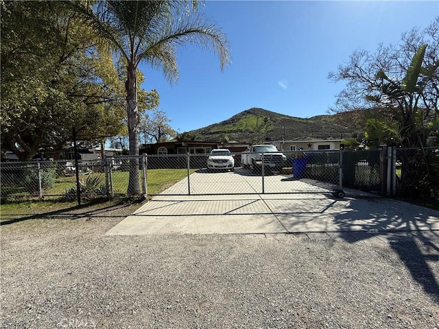 view of gate with a fenced front yard and a mountain view