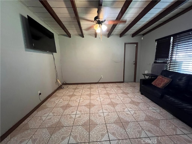 unfurnished living room featuring light tile patterned flooring, beamed ceiling, baseboards, and ceiling fan