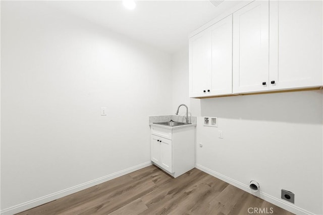 washroom featuring hookup for a washing machine, hookup for an electric dryer, a sink, light wood-style floors, and cabinet space