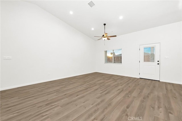 unfurnished living room featuring lofted ceiling, wood finished floors, visible vents, and baseboards