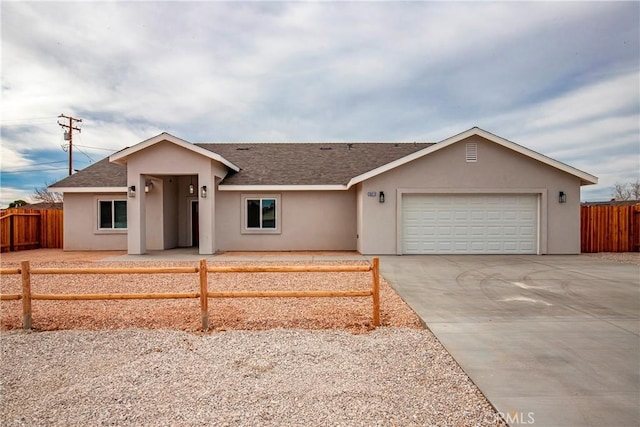 ranch-style home featuring a garage, fence, driveway, roof with shingles, and stucco siding