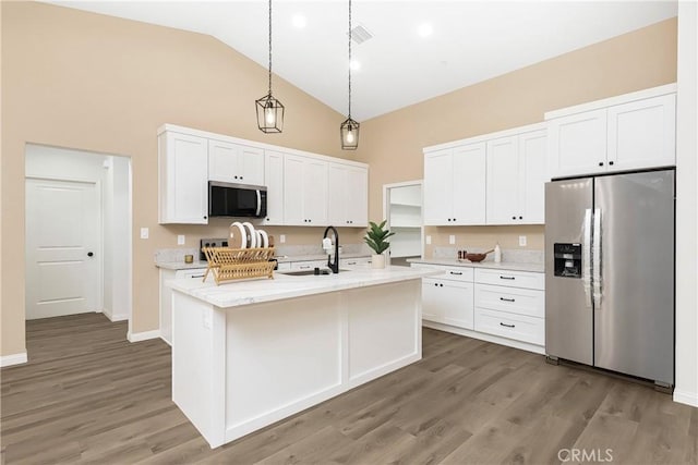 kitchen featuring appliances with stainless steel finishes, white cabinetry, a sink, and wood finished floors