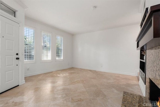 unfurnished living room with baseboards