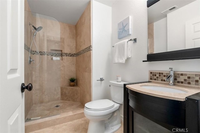 full bath with visible vents, toilet, backsplash, tiled shower, and vanity