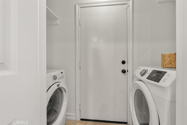 clothes washing area with washing machine and clothes dryer and laundry area