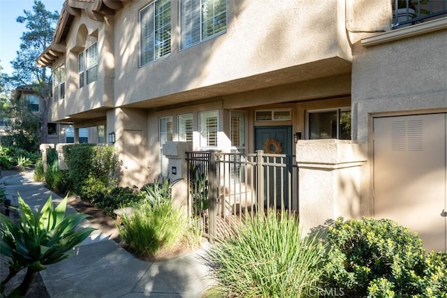 property entrance with fence and stucco siding