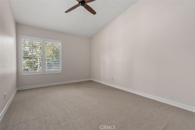 unfurnished room featuring lofted ceiling, baseboards, carpet floors, and ceiling fan