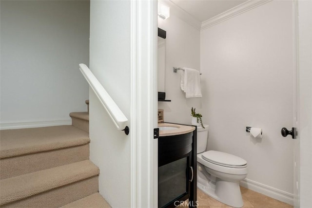 bathroom with baseboards, toilet, ornamental molding, tile patterned floors, and vanity