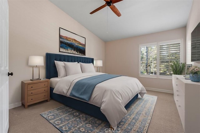 bedroom with vaulted ceiling, light colored carpet, baseboards, and ceiling fan