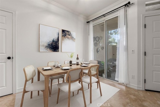 dining area featuring crown molding and baseboards