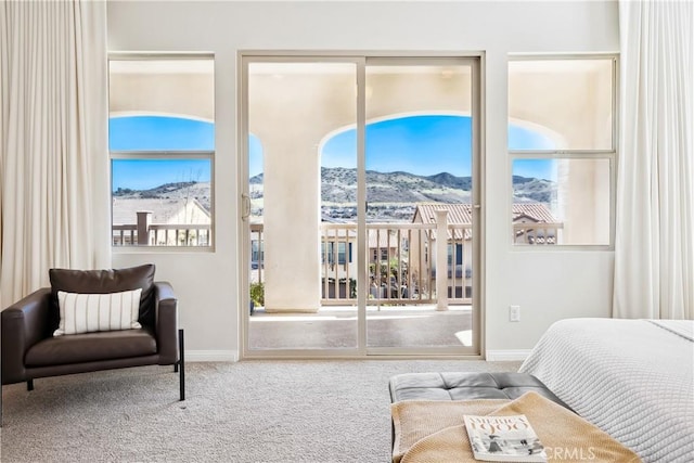 carpeted bedroom featuring access to exterior, multiple windows, a mountain view, and baseboards