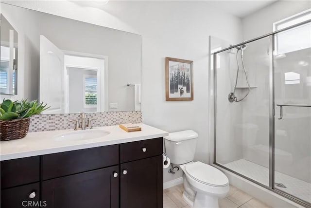 bathroom featuring vanity, a shower stall, toilet, and decorative backsplash