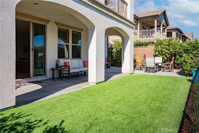 exterior space with a balcony, an outdoor living space, and a patio