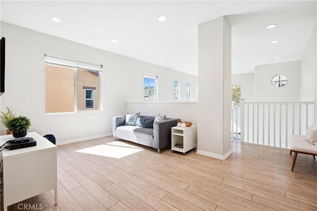 living room featuring baseboards, light wood-style flooring, and recessed lighting