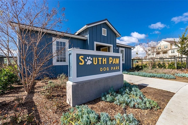 community sign with concrete driveway and fence