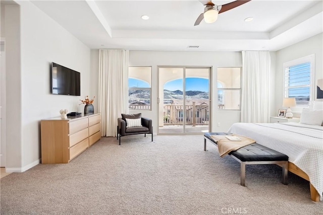 bedroom featuring a tray ceiling, visible vents, light carpet, access to outside, and baseboards