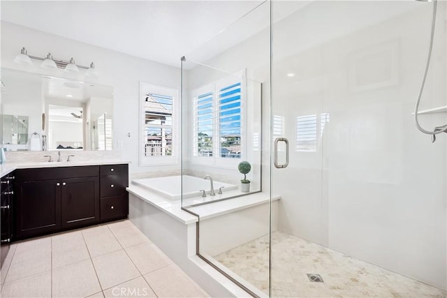 full bathroom with a stall shower, tile patterned flooring, a garden tub, and vanity