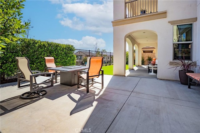 view of patio / terrace with outdoor dining space, fence, and a balcony