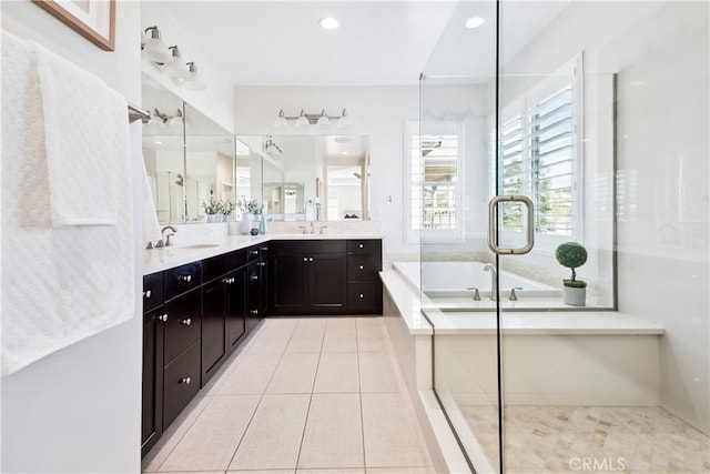 full bath featuring a sink, a shower stall, a bath, tile patterned floors, and double vanity