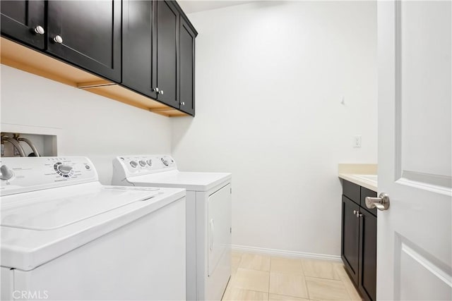 laundry area with cabinet space, baseboards, and washer and clothes dryer