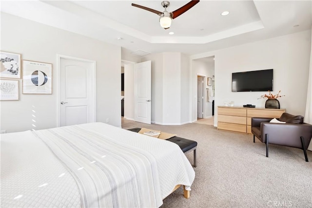 bedroom with ceiling fan, recessed lighting, light carpet, baseboards, and a tray ceiling