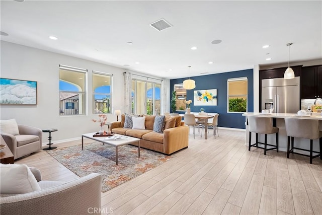 living room featuring light wood-style floors, recessed lighting, visible vents, and baseboards