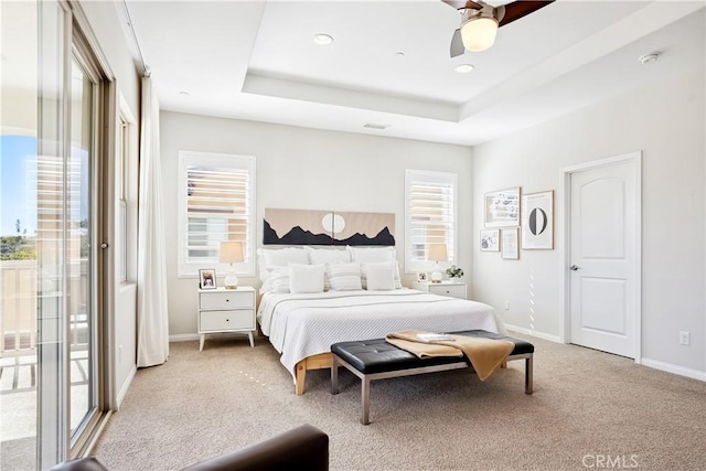 bedroom with access to outside, a raised ceiling, light colored carpet, and baseboards