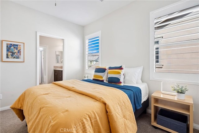 bedroom with carpet flooring, connected bathroom, and baseboards