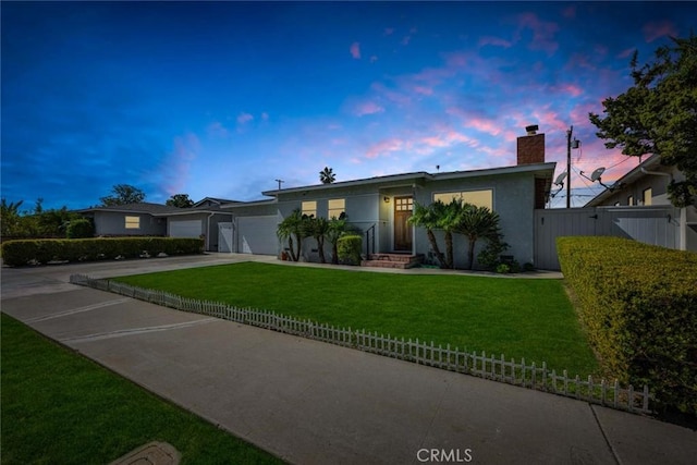 single story home with a garage, fence, concrete driveway, a yard, and stucco siding