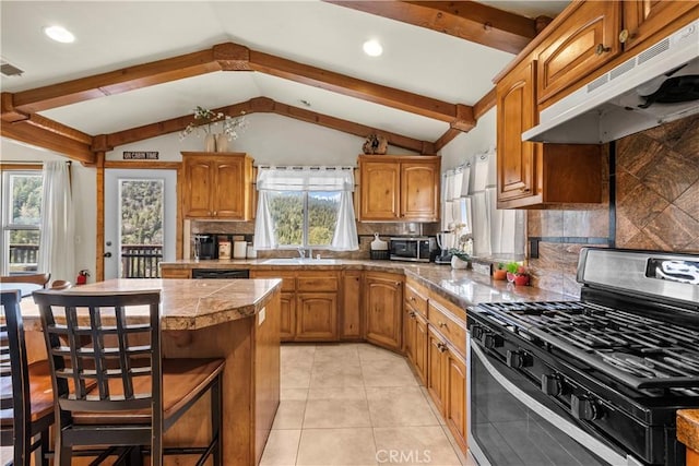 kitchen featuring a center island, a breakfast bar area, stainless steel appliances, a sink, and under cabinet range hood