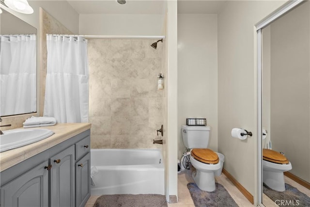 full bath featuring shower / bathtub combination with curtain, toilet, vanity, baseboards, and tile patterned floors