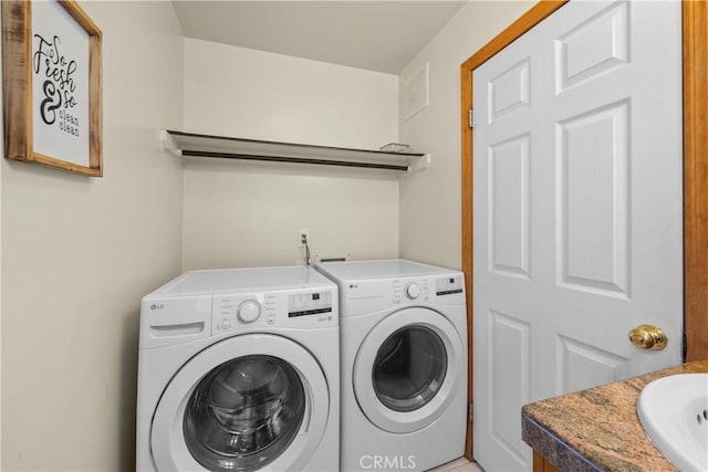 laundry room featuring laundry area, visible vents, a sink, and separate washer and dryer