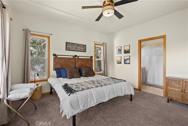 carpeted bedroom featuring ensuite bathroom, a ceiling fan, and baseboards