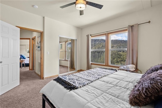 carpeted bedroom with a closet, ceiling fan, and baseboards