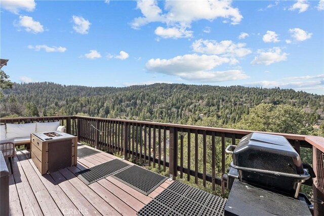 820 Arbula Dr, Crestline, CA 92325 - wooden terrace featuring grilling area, an outdoor fire pit, and a view of trees
