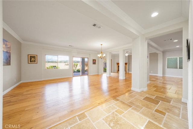 empty room with visible vents, an inviting chandelier, ornamental molding, light wood-style floors, and baseboards