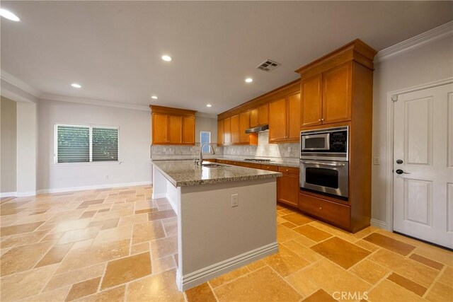 kitchen featuring a sink, visible vents, appliances with stainless steel finishes, brown cabinets, and stone tile flooring