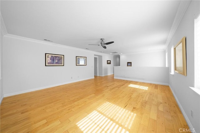 unfurnished living room with light wood finished floors, baseboards, visible vents, ceiling fan, and crown molding