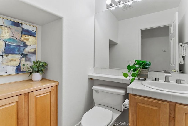 bathroom featuring visible vents, vanity, and toilet