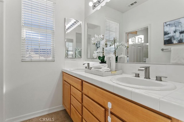 full bath with double vanity, tile patterned flooring, visible vents, and a sink