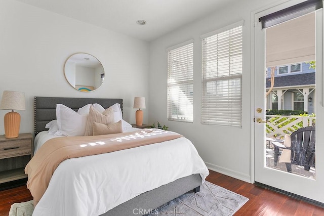 bedroom featuring access to outside, baseboards, and wood finished floors