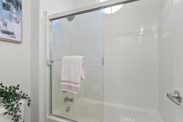 bathroom featuring bath / shower combo with glass door