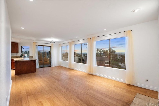 unfurnished living room featuring light wood-style floors, baseboards, and recessed lighting