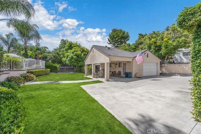 exterior space featuring a lawn, fence, stucco siding, an attached garage, and a tile roof