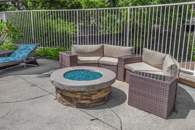 view of patio / terrace featuring fence and an outdoor living space with a fire pit