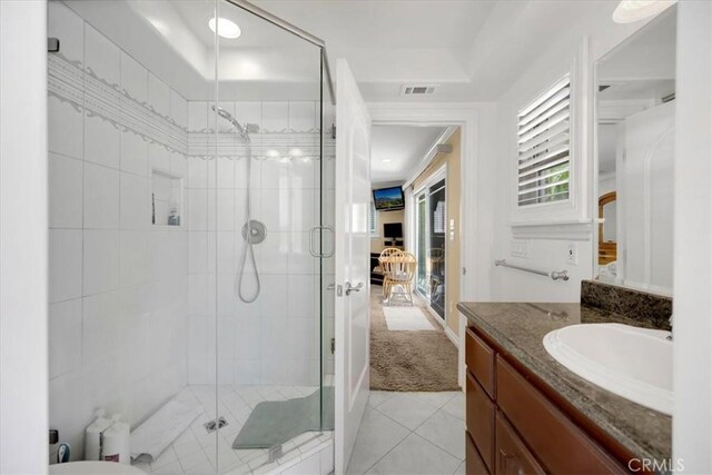 bathroom featuring visible vents, tile patterned flooring, a stall shower, and vanity