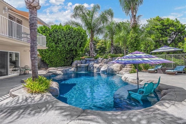 pool featuring fence and a patio area
